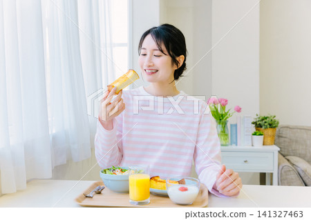 A woman eating toast for breakfast A woman eating toast for breakfast 141327463