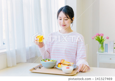 Young woman eating breakfast at home Young woman eating breakfast at home 141327469