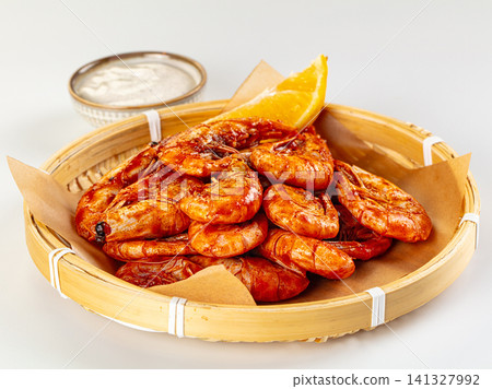 Spicy glazed shrimp in bamboo basket with citrus wedge and dipping sauce Spicy glazed shrimp in bamboo basket with citrus wedge and dipping sauce 141327992