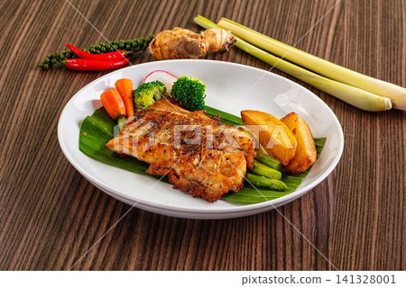 Grilled chicken steak with roasted potatoes and vegetables on banana leaf Grilled chicken steak with roasted potatoes and vegetables on banana leaf 141328001