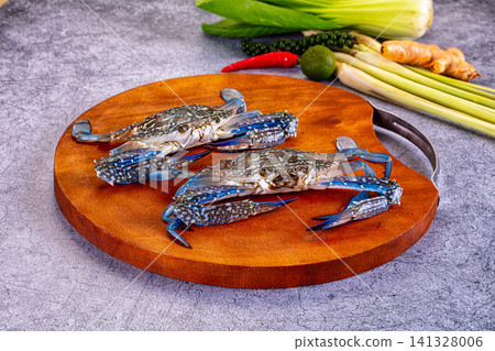 Fresh blue crabs on wooden cutting board with lemongrass chili lime ginger Fresh blue crabs on wooden cutting board with lemongrass chili lime ginger 141328006