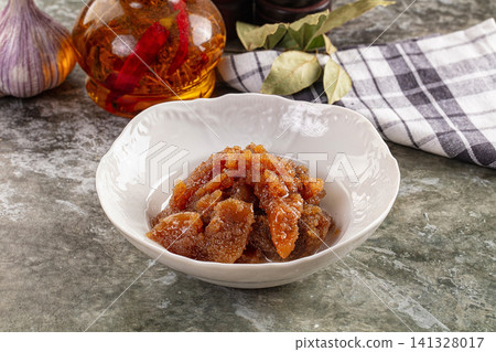 Caviar in white bowl with garlic and spice oil on rustic stone surface 141328017