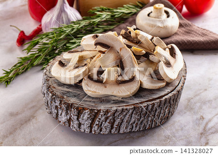 Sliced mushrooms on rustic wooden board with rosemary garlic and tomatoes Sliced mushrooms on rustic wooden board with rosemary garlic and tomatoes 141328027