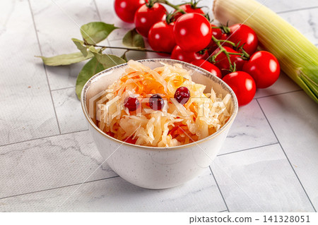 Sauerkraut with cranberries in ceramic bowl with cherry tomatoes and leek Sauerkraut with cranberries in ceramic bowl with cherry tomatoes and leek 141328051