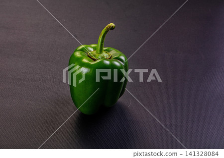 Fresh green bell pepper on dark textured background Fresh green bell pepper on dark textured background 141328084