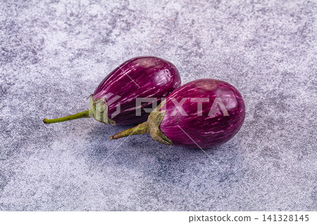 Two purple striped eggplants on textured gray surface Two purple striped eggplants on textured gray surface 141328145