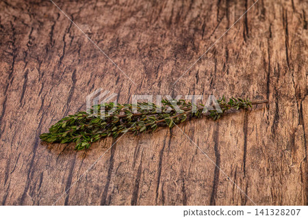 Fresh thyme sprig on rustic wooden surface Fresh thyme sprig on rustic wooden surface 141328207