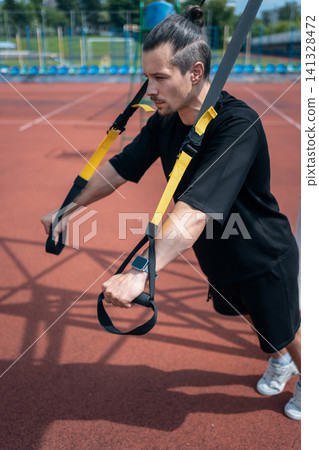 yound sporty athlete or bodybuilder has fitness workout with trx outdoor yound sporty athlete or bodybuilder has fitness workout with trx outdoor 141328472