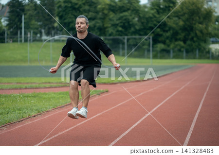 young athlete has workout and jumps on skipping rope outdoor young athlete has workout and jumps on skipping rope outdoor 141328483