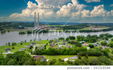 Air pollution and environment contamination concept. Residential district houses at coal-fired power plant producing electricity. Fossil fuel usage for energy production Air pollution and environment contamination concept. Residential district houses at coal-fired power plant producing electricity. Fossil fuel usage for energy production 141329388