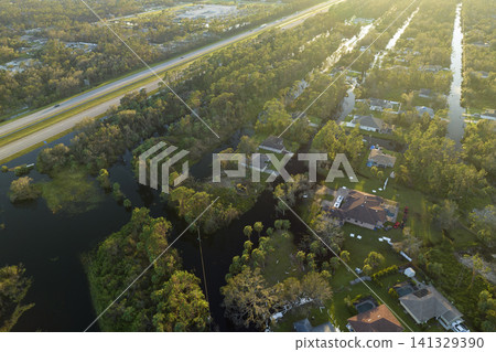 Aftermath of natural disaster. Surrounded by hurricane rainfall flood waters homes in Florida residential area Aftermath of natural disaster. Surrounded by hurricane rainfall flood waters homes in Florida residential area 141329390