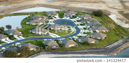 Aerial view of private homes in Florida residential area. New family houses as example of real estate development in American suburbs Aerial view of private homes in Florida residential area. New family houses as example of real estate development in American suburbs 141329417