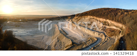 Aerial view of open pit mining site of limestone materials for construction industry with excavators and dump trucks Aerial view of open pit mining site of limestone materials for construction industry with excavators and dump trucks 141329418