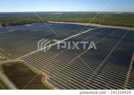 Aerial view of large sustainable electrical power plant with rows of solar photovoltaic panels for producing clean electric energy. Concept of renewable electricity with zero emission Aerial view of large sustainable electrical power plant with rows of solar photovoltaic panels for producing clean electric energy. Concept of renewable electricity with zero emission 141329428