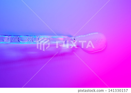 Cosmetic serum dropper dispensing liquid on vibrant background Cosmetic serum dropper dispensing liquid on vibrant background 141330157