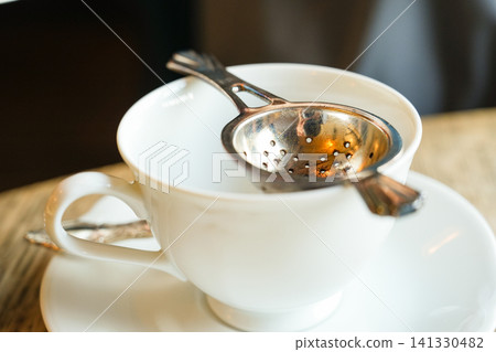 茶杯和茶漏靜靜地佇立著。 茶杯和茶漏靜靜地佇立著。 141330482
