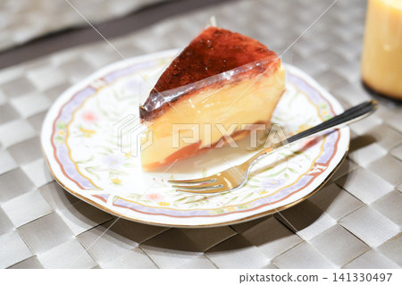 A baked cheesecake I bought from a cake shop, served on a floral plate. A baked cheesecake I bought from a cake shop, served on a floral plate. 141330497