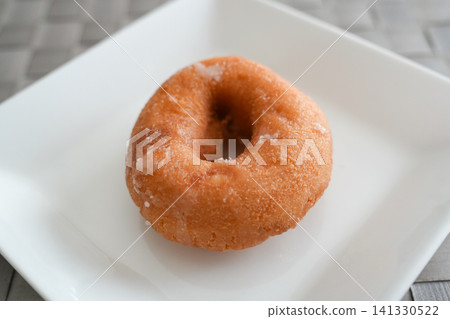 A classic donut with a gleaming glaze. A classic donut with a gleaming glaze. 141330522