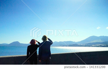 一對美國夫婦的背影和波光粼粼的大海。 一對美國夫婦的背影和波光粼粼的大海。 141331200