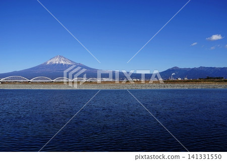 Mount Fuji, Mount Ashitaka, and the Fujikawa River stand out against the blue sky. January, Mount Fuji 2101, Mount Ashitaka and Fujikawa Aqueduct Bridge. Mount Fuji, Mount Ashitaka, and the Fujikawa River stand out against the blue sky. January, Mount Fuji 2101, Mount Ashitaka and Fujikawa Aqueduct Bridge. 141331550