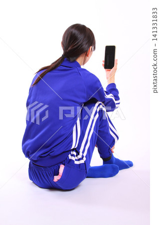 一位身穿運動服的女子正在使用智慧型手機 141331833