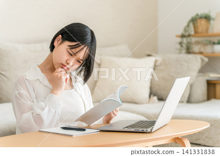 A high school girl and a middle school girl who are troubled by studying in the living room. A high school girl and a middle school girl who are troubled by studying in the living room. 141331838