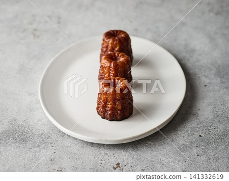 Canelés on a white plate Canelés on a white plate 141332619