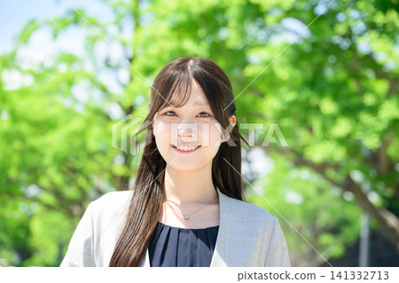 A female businessperson smiles while looking at the camera. 141332713