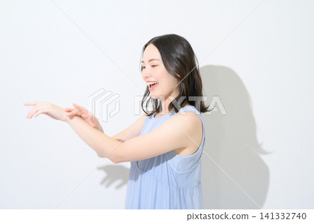 A beauty image of a Japanese woman applying sunscreen to her arm against a white background. A beauty image of a Japanese woman applying sunscreen to her arm against a white background. 141332740