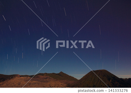 mountain landscape beneath a spectacular night sky filled with circular star trails, capturing the Earth's rotation and beauty of long exposure photography for travel promotion, astronomy publication mountain landscape beneath a spectacular night sky filled with circular star trails, capturing the Earth's rotation and beauty of long exposure photography for travel promotion, astronomy publication 141333276