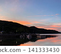 A quiet harbor bathed in the sunset and a calm sea the color of crimson. 141333430