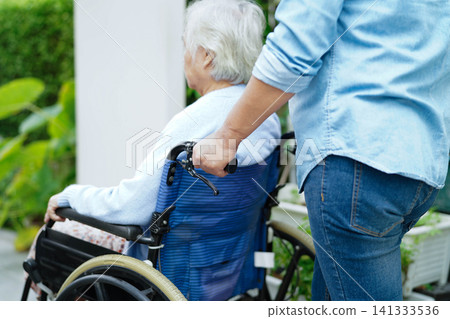 Caregiver help Asian elderly woman disability patient sitting on wheelchair in hospital. Caregiver help Asian elderly woman disability patient sitting on wheelchair in hospital. 141333536
