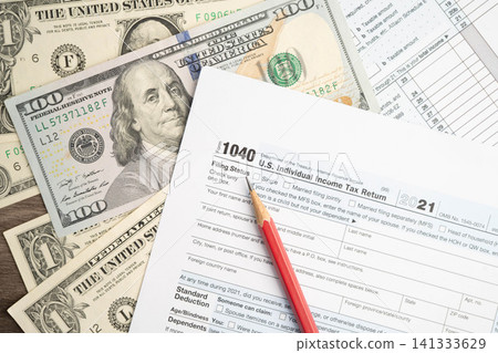 Tax form 1040 U.S. Individual Income Tax Return with dollar banknotes money. Tax form 1040 U.S. Individual Income Tax Return with dollar banknotes money. 141333629