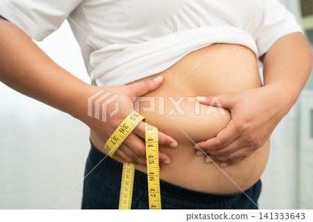 Asian woman use hand to squeeze fat belly big size overweight and obesity. 141333643