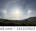 A sun dog and halo appeared over the Utsukushigahara Plateau, with summer daylilies and a blue sky. Nagano Prefecture. 141333923