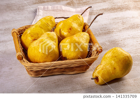 Fresh yellow pears wicker basket rustic table still life Fresh yellow pears wicker basket rustic table still life 141335709