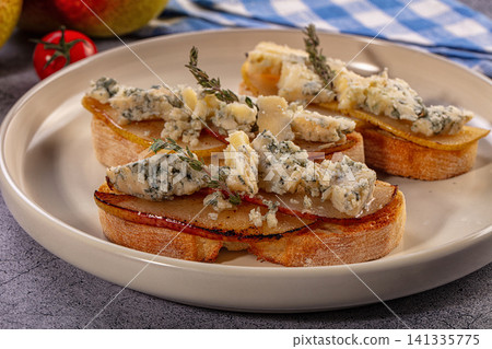 Bruschetta with caramelized pear and blue cheese 141335775