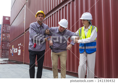 Group of workers help male worker whom faint ,sick or got accident during work, carry him to hospital. Industrial and container work accident concept. Group of workers help male worker whom faint ,sick or got accident during work, carry him to hospital. Industrial and container work accident concept. 141336432