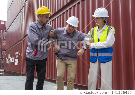 Group of workers help male worker whom faint ,sick or got accident during work, carry him to hospital. Industrial and container work accident concept. Group of workers help male worker whom faint ,sick or got accident during work, carry him to hospital. Industrial and container work accident concept. 141336433
