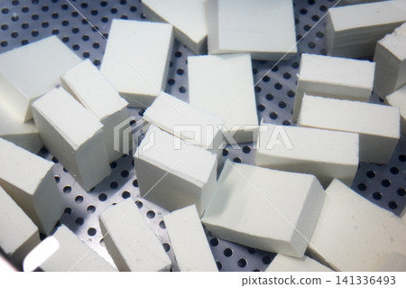 Freshly made silken tofu being chilled in a water tank. Freshly made silken tofu being chilled in a water tank. 141336493