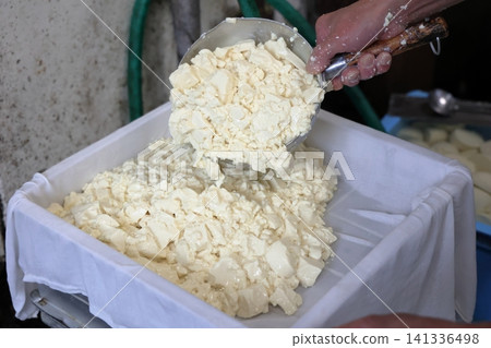 在製作硬豆腐的過程中,將豆腐麵團放入模具中成型。 在製作硬豆腐的過程中,將豆腐麵團放入模具中成型。 141336498
