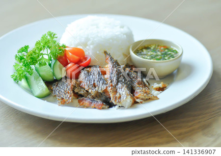 fried fish and rice , fried tilapia fish and rice or fish and rice 141336907