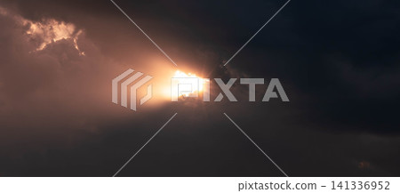 奇異的景象:一束光線穿過漆黑雲層的縫隙照射進來。 奇異的景象:一束光線穿過漆黑雲層的縫隙照射進來。 141336952