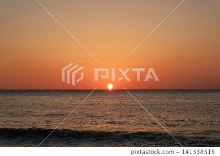 The mystical Daruma-shaped sunrise and the morning glow over the sea at the moment the sun completely leaves the horizon. The mystical Daruma-shaped sunrise and the morning glow over the sea at the moment the sun completely leaves the horizon. 141338318
