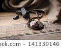 An antique leather sling lies on wooden desk 141339146
