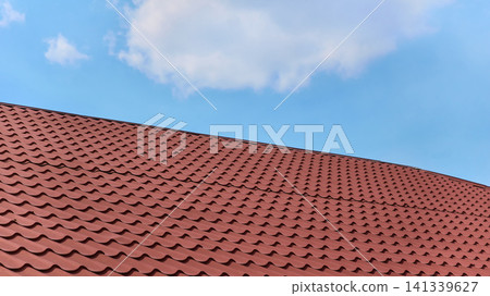 Plastic ceramic metal tile profile on roof of house and blue sky 141339627