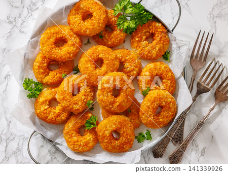Golden Breaded Cheese Wheels On Paper on a tray Golden Breaded Cheese Wheels On Paper on a tray 141339926