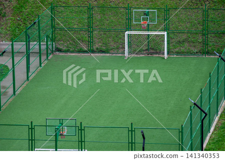 Empty outdoor sports court with goal and basketball hoops Empty outdoor sports court with goal and basketball hoops 141340353