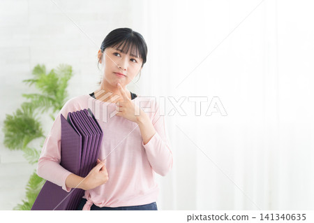 Young women in yoga wear thinking Young women in yoga wear thinking 141340635