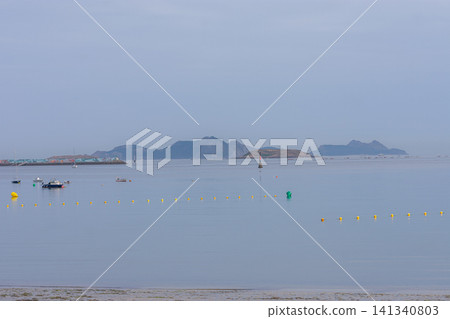The Cies Islands are glimpsed on the hazy horizon from the tranquil Ladeira beach in Baiona, Galicia. The Cies Islands are glimpsed on the hazy horizon from the tranquil Ladeira beach in Baiona, Galicia. 141340803